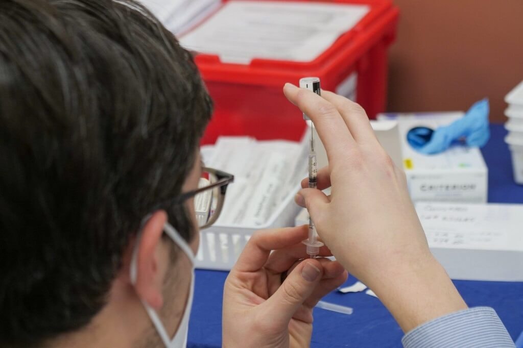 Doctor preparing needle for vaccine 